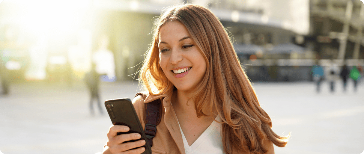 surprised-student-girl-watching-excited-her-smartphone-city-street 1-min