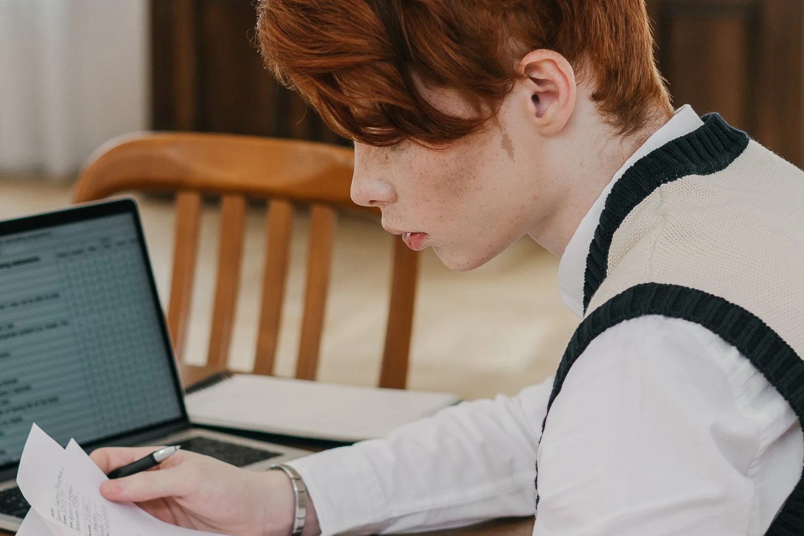 college student reviewing financial aid paperwork at a table