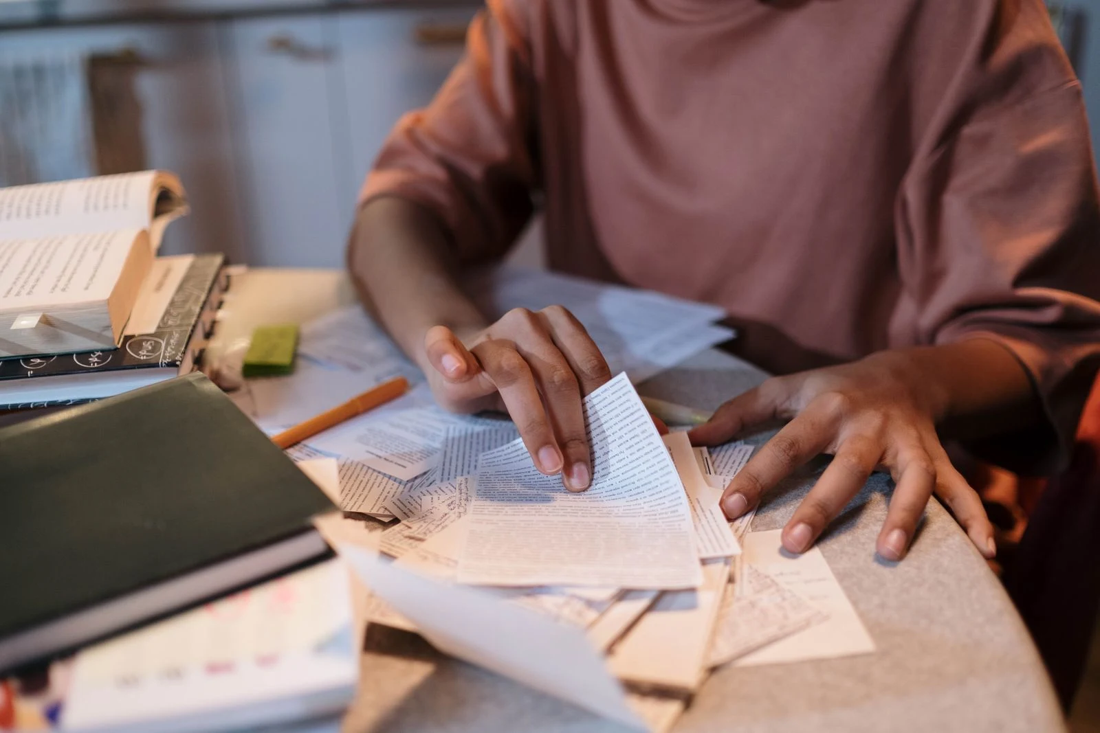 student sorting study notes and textbooks at a table while working on financial aid